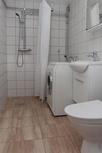 乌普萨拉Cottage in forest的配有洗衣机和水槽的浴室