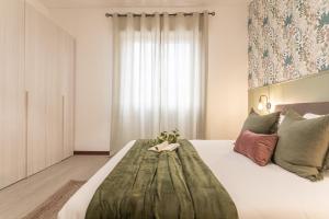 een slaapkamer met een groot bed met een groot raam bij Posidonia - Free Parking & Netflix - 200m to Beach in Fiumicino +14 foto's