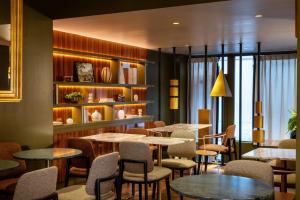 a restaurant with tables and chairs and a shelf at Hôtel Aoriste & Spa in Paris