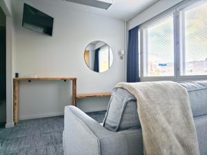 a living room with a chair and a mirror at Nature Hotel Kuutti in Savonlinna