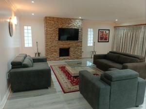 a living room with two couches and a fireplace at Pioneer Guest House in Kloof