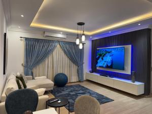 a living room with a couch and a tv at Jupiter Villa 1 and 2 in Afienya