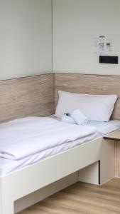 a bed with white sheets and a wooden headboard at Roatel Gau-Bickelheim A61 my-roatel-com in Gau-Bickelheim