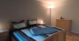 a bedroom with a bed and a dresser with a lamp at Haus Wolfgang in Geldern