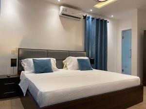 a bedroom with a large bed with blue curtains at Jupiter Villa 1 and 2 in Afienya