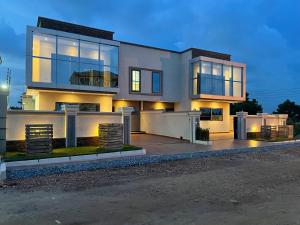 a large house with a lot of windows at Jupiter Villa 1 and 2 in Afienya