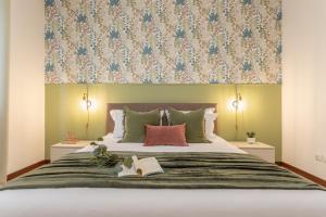 een slaapkamer met een groot bed met een bloemrijk hoofdeinde bij Posidonia - Free Parking & Netflix - 200m to Beach in Fiumicino