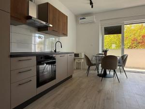 a kitchen with a stove and a table with chairs at Apartment Mark - Old Town of Sinj view, parking in Sinj +13 photos