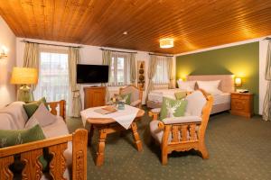 a living room with a couch and a bed at Hotel garni Reiffenstuel in Rottach-Egern