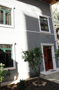 ein weißes Haus mit einem Baum davor in der Unterkunft Hostel Vila H in Tirana