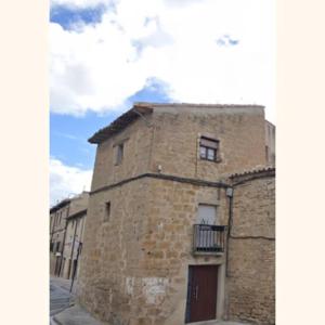 un antiguo edificio de ladrillo con puerta y balcón en La torre romana, en Olite