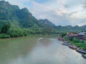 a river with a bunch of boats on it at Nongkhiaw view Guest house in Nongkhiaw