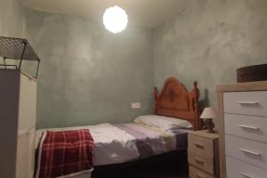 Un dormitorio con una cama y una cómoda. en La torre romana, en Olite
