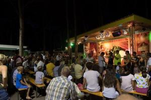 Une foule de personnes assises devant une scène dans l'établissement Cozy 2 bedroom Cabin sleeps 5 in Lido di Spina, Italy - Perfect Family Retreat, à Lido di Spina