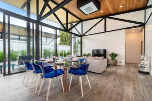 une salle à manger avec une table et des chaises bleues dans l'établissement NEW! Sleek Design Oxygen Pool Villa 3 BR - Sunset Garden 14, à Ban Saiyuan (1)