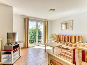 a living room with a couch and a tv at Vacancéole - Port Minervois, Les Hauts du Lac in Homps