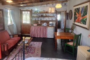 a living room with a table and a kitchen at Cottage on Roux in Smithfield