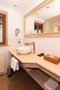 a bathroom with a sink and a mirror at Hotel garni Reiffenstuel in Rottach-Egern +49 photos