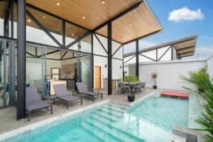 - une piscine intérieure dans une maison aux parois de verre dans l'établissement NEW! Sleek Design Oxygen Pool Villa 3 BR - Sunset Garden 14, à Ban Saiyuan (1)