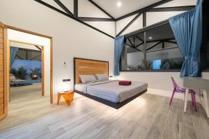 une chambre avec un lit, une table et un bureau dans l'établissement NEW! Sleek Design Oxygen Pool Villa 3 BR - Sunset Garden 14, à Ban Saiyuan (1) 35 autres photos