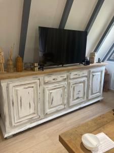 ein großes weißes Entertainment-Center mit einem Fernseher darauf in der Unterkunft L'armorique in Saint Die