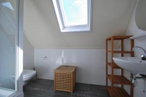 Un baño con lavabo, inodoro y ventana. en Beachvilla Luxe met Sauna - 6 personen, en Holle Poarte 13 fotos más