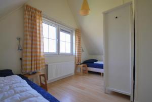 un dormitorio con una cama y una ventana en Beachvilla Luxe met Sauna - 6 personen, en Holle Poarte