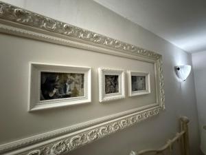 three framed pictures on a wall in a room at Valletta apartment in Valletta +1 photo