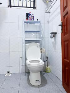 a bathroom with a white toilet in a stall at Seil Apartment in Kampala +37 photos