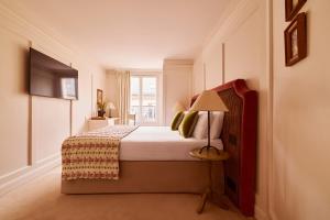 a bedroom with a bed with a lamp and a window at Hotel Maison Monceau in Paris