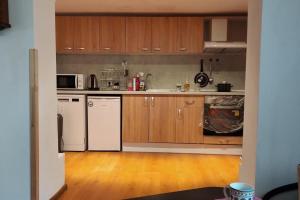 a kitchen with wooden cabinets and white appliances at 2 Bed Villa - Sleeps 7 - Private Garden - Parking in Tŭnkovo +5 photos