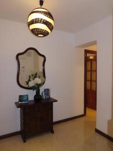 a hallway with a mirror and a table with a vase of flowers at Pizarro Apartment in Villajoyosa +12 photos