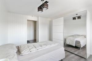 un dormitorio con paredes blancas y dos camas. en Centrum Apartment, en Ålesund