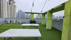a rooftop deck with two ping pong tables and a grill at Rare House 4 in Incheon