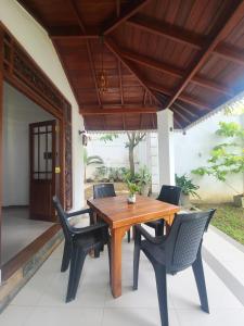 a wooden table and chairs on a patio at AfterFly in Ahangama