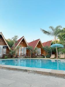 a resort with a swimming pool in front of houses at Vinn Villa, Coffee & Resto in Bugel