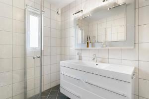 Un baño blanco con lavabo y espejo. en Centrum Apartment, en Ålesund 23 fotos más