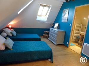 a attic bedroom with two beds and a television at Gîte à Verlac in Verlac