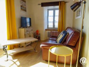 a living room with a leather couch and a table at Gîte à Verlac in Verlac