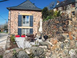 a stone house with a table and a stone wall at Gîte à Verlac in Verlac