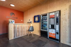 a room with a drink machine and a chair at CROSINA HOLIDAY - Residence Toli in Ledro