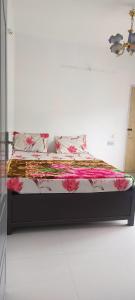 un lit dans une chambre blanche avec des fleurs roses dessus dans l'établissement December Holiday inn 2BHK House, à Kodaikānāl