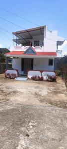 une maison blanche avec un toit rouge dans l'établissement December Holiday inn 2BHK House, à Kodaikānāl
