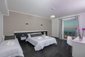 a bedroom with two beds and a view of the ocean at Hotel Baia D'oro in Licata +68 photos