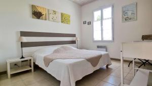 een witte slaapkamer met een bed en een raam bij Au lieu dit La Passe , Villa individuelle de plain pied, avec beaucoup de charme in La Couarde-sur-Mer