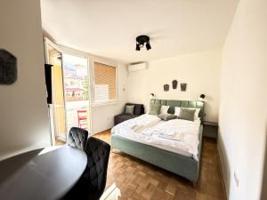 ein Schlafzimmer mit einem Bett und einem großen Fenster in der Unterkunft Ma Bel Apartments Sarajevo in Sarajevo