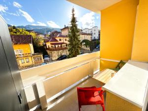 einen roten Stuhl in einem Zimmer mit Fenster in der Unterkunft Ma Bel Apartments Sarajevo in Sarajevo