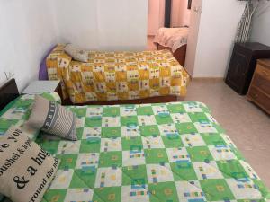 a bedroom with two beds and a quilt on a bed at La Casa los Trancos, a 15 minutos de Cazorla in Peal de Becerro