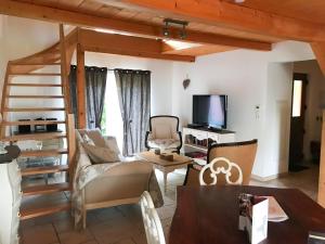 a living room with a couch and a tv at Les Authentics - Le Domaine d'Autrefois & Spa in Bolsenheim