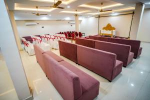 a room with rows of chairs and a stage at Aryavart Hotel in Ayodhya
